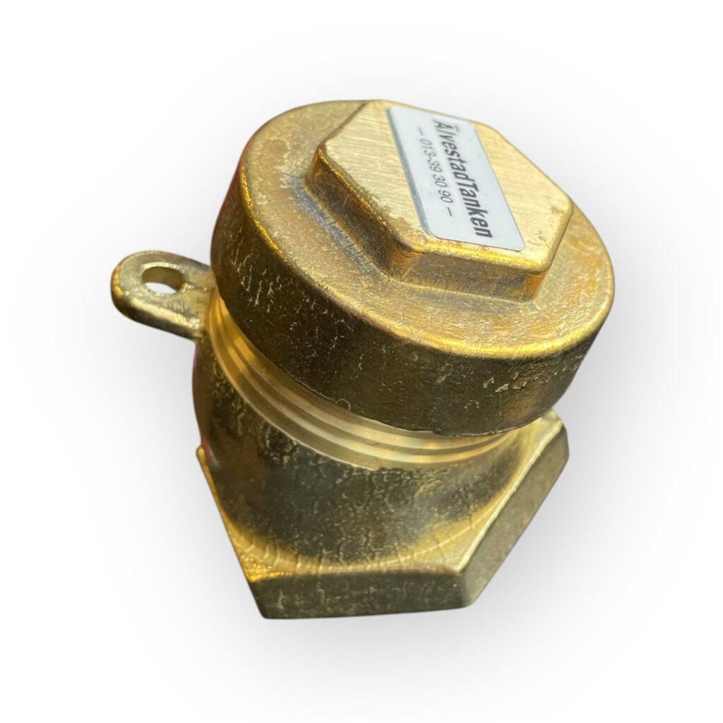 TANKLOCK 2 TUM MÄSSING 30° är ett mässingslock med sexkantig bas, stor ögla på sidan, klisteretikett på toppen och en grov, strukturerad yta.