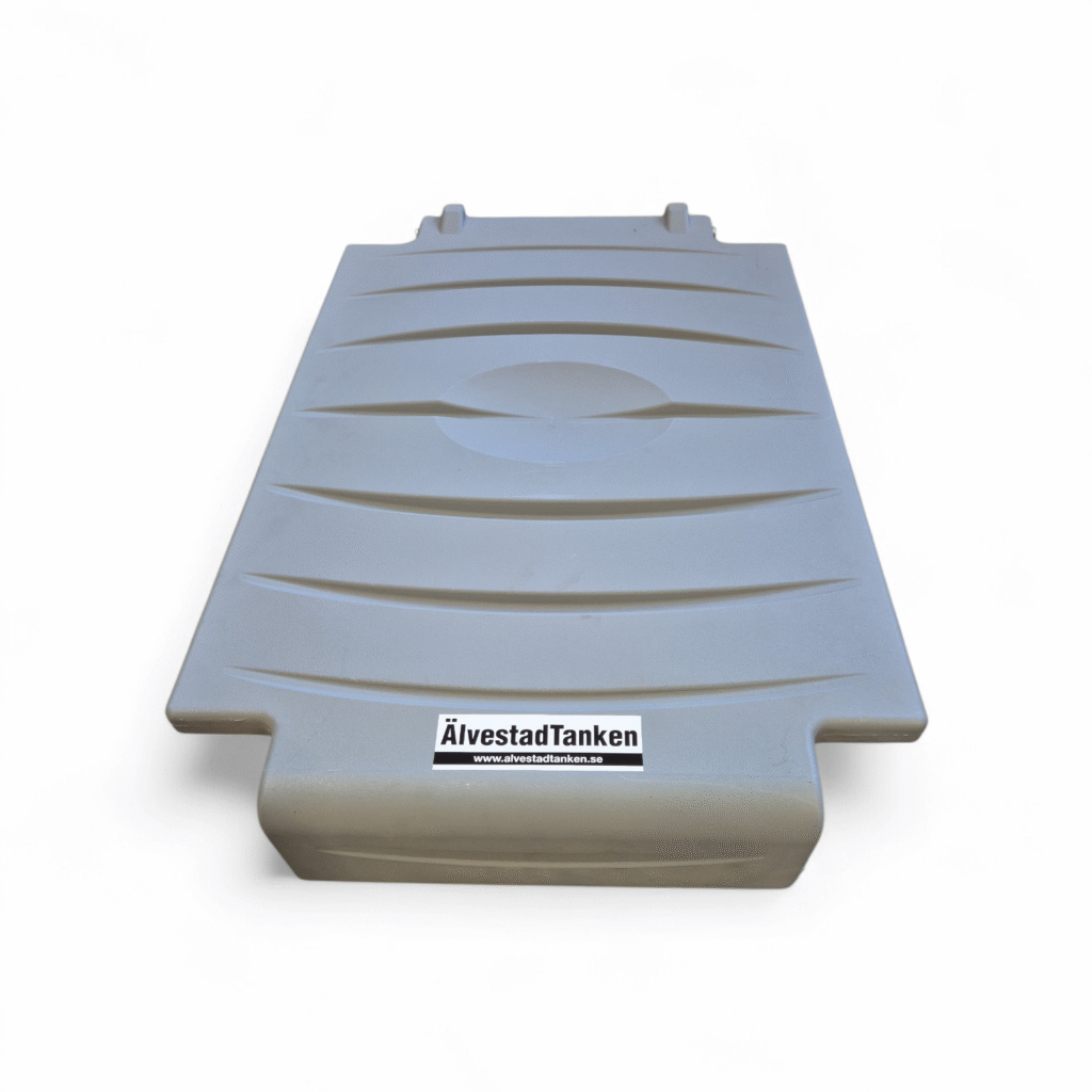 Ett stort, rektangulärt, grått plastlock till Lock till Carrytank 220L har räfflade linjer och en etikett på framsidan med en webbadress. Locket visas ovanifrån mot en vit bakgrund.
