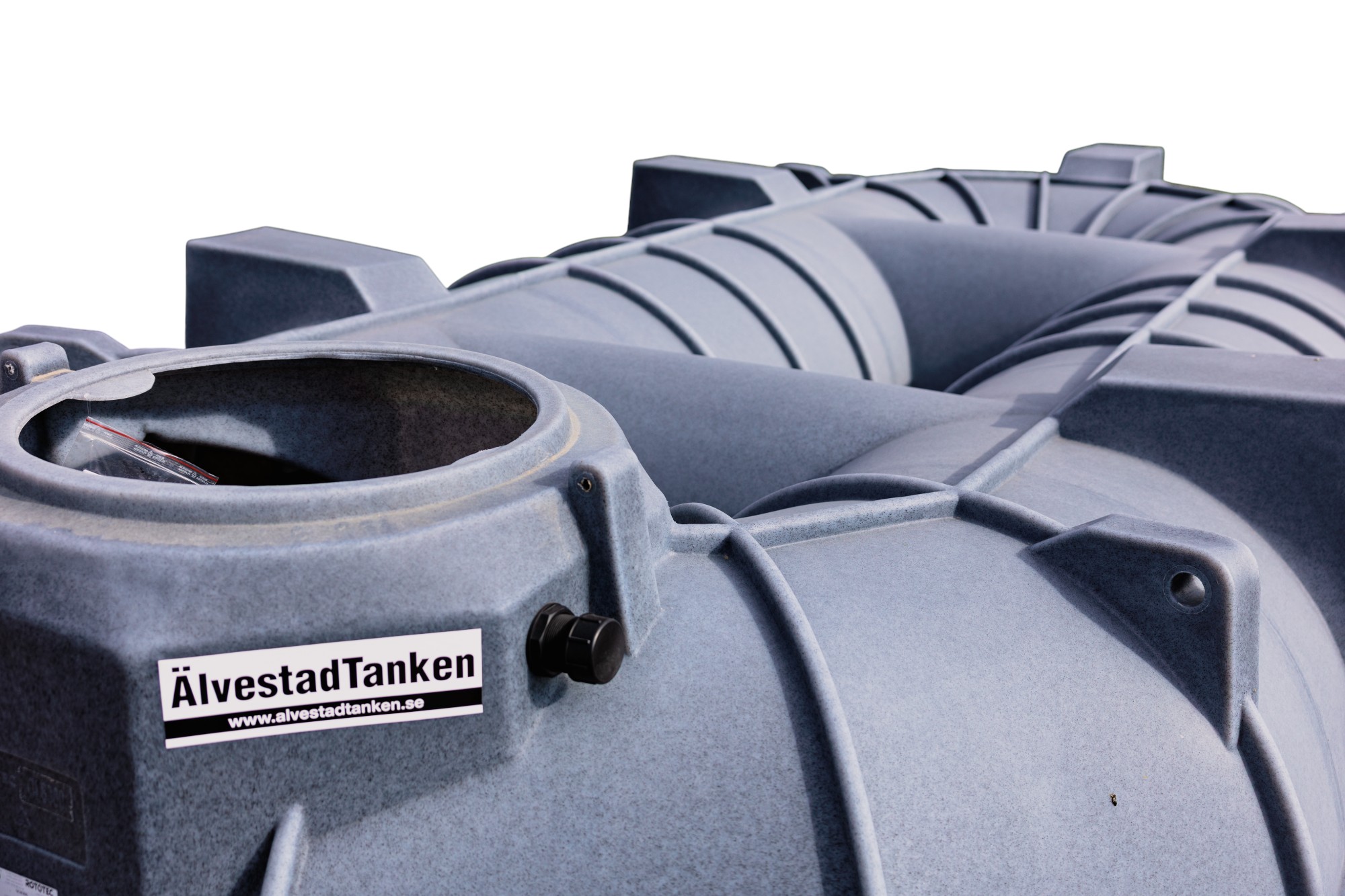 Närbild av en stor grå industriell Sluten Tank CL 8300L Lågbyggd i plast med en cirkulär öppning och strukturella åsar. På en etikett mot vit bakgrund står det ÄlvestadTanken med en länk till en webbplats under.