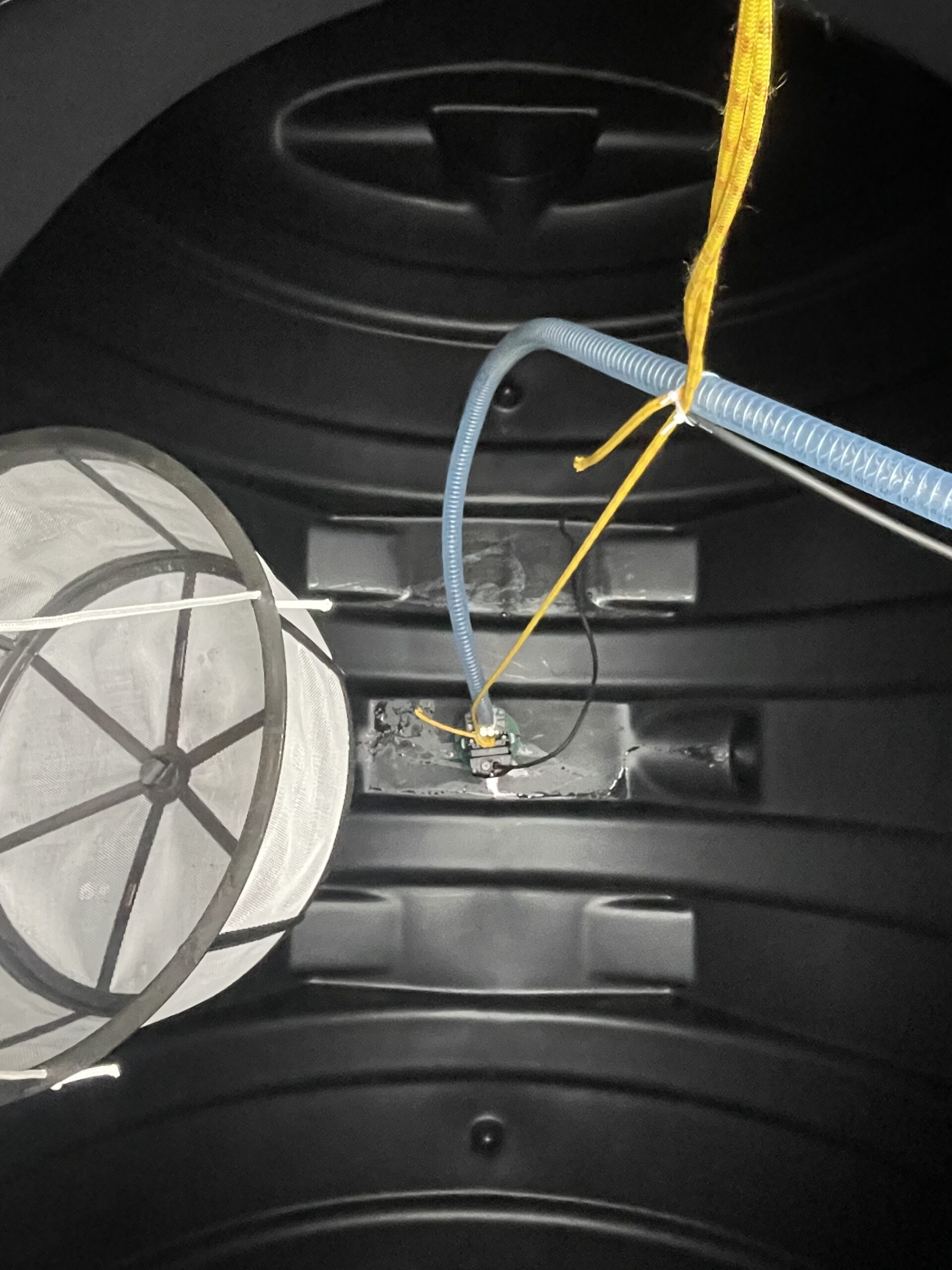 Inuti ÄlvestadTankens regnvattentank på 10.000 liter är en gul rem och ett blått flexibelt rör fästa upptill, med ett cylindriskt filter till vänster. Blixtbelysning avslöjar tankens interiör och armaturer.