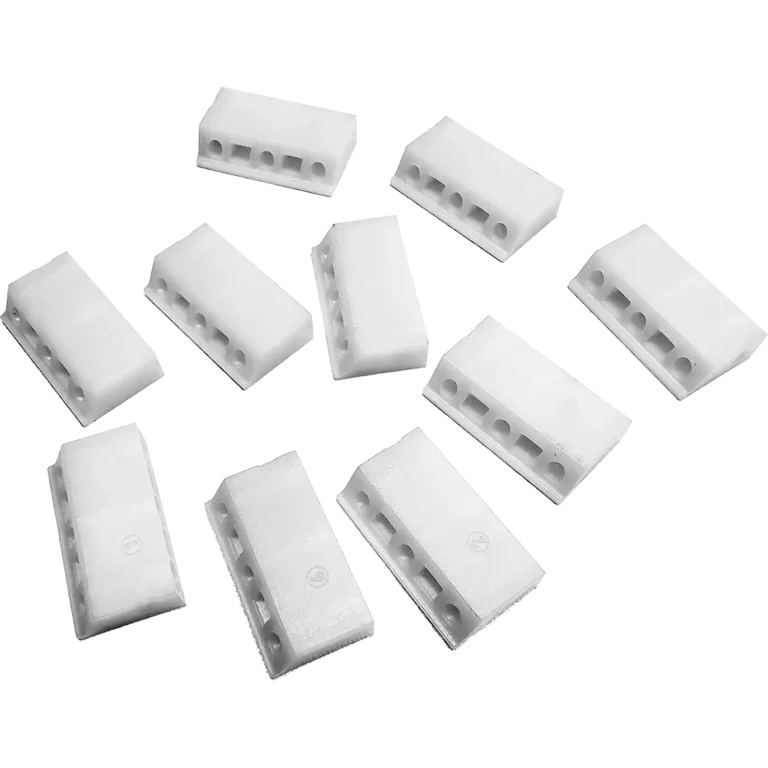 Tio vita plastplintar, var och en med tre hål för kabelgenomföring, är utspridda på en slät bakgrund - perfekt för projekt där Kit fjäder och skovlar BP3000 och BIPUMP används.