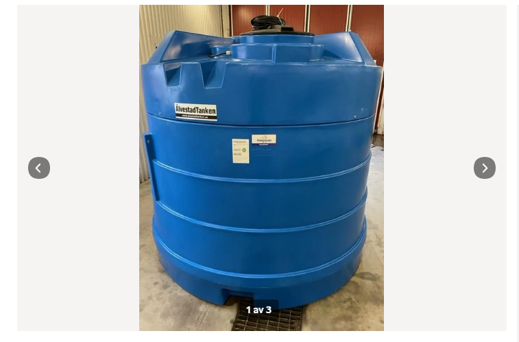 En stor blå Nödvattentank isolerad 3500 liter i plast står inomhus på ett betonggolv. Den cylindriska tanken med kupolformad topp är märkt "NivåstatTanken" och har en liten åtkomstlucka och en etikett fäst på sidan.