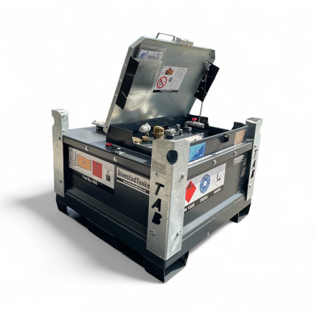 En stor Dieseltank ADR Fuel Box 450 liter i metall med delvis öppet lock som avslöjar ventiler och mätare inuti. Behållaren har varningsetiketter, säkerhetsdekaler och förstärkta metallhörn för ökad hållbarhet.