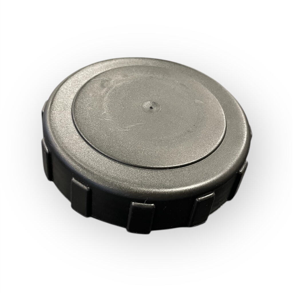 Ett svart, runt Tanklock Truckmaster 200-300L lock i plast med räfflade kanter, mot en vit bakgrund.
