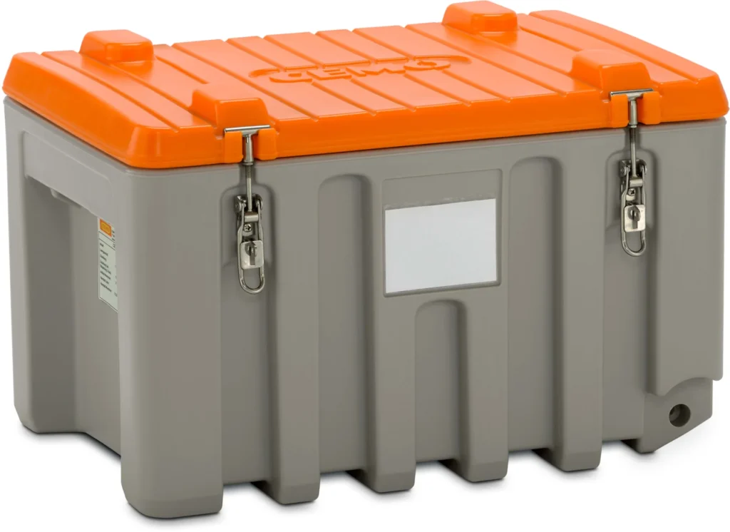 En robust kylbox i grått och orange med metallspärrar, ett plant lock och en vit rektangulär etikett på framsidan. Kylboxen har handtag på båda sidor och står på en vit bakgrund.