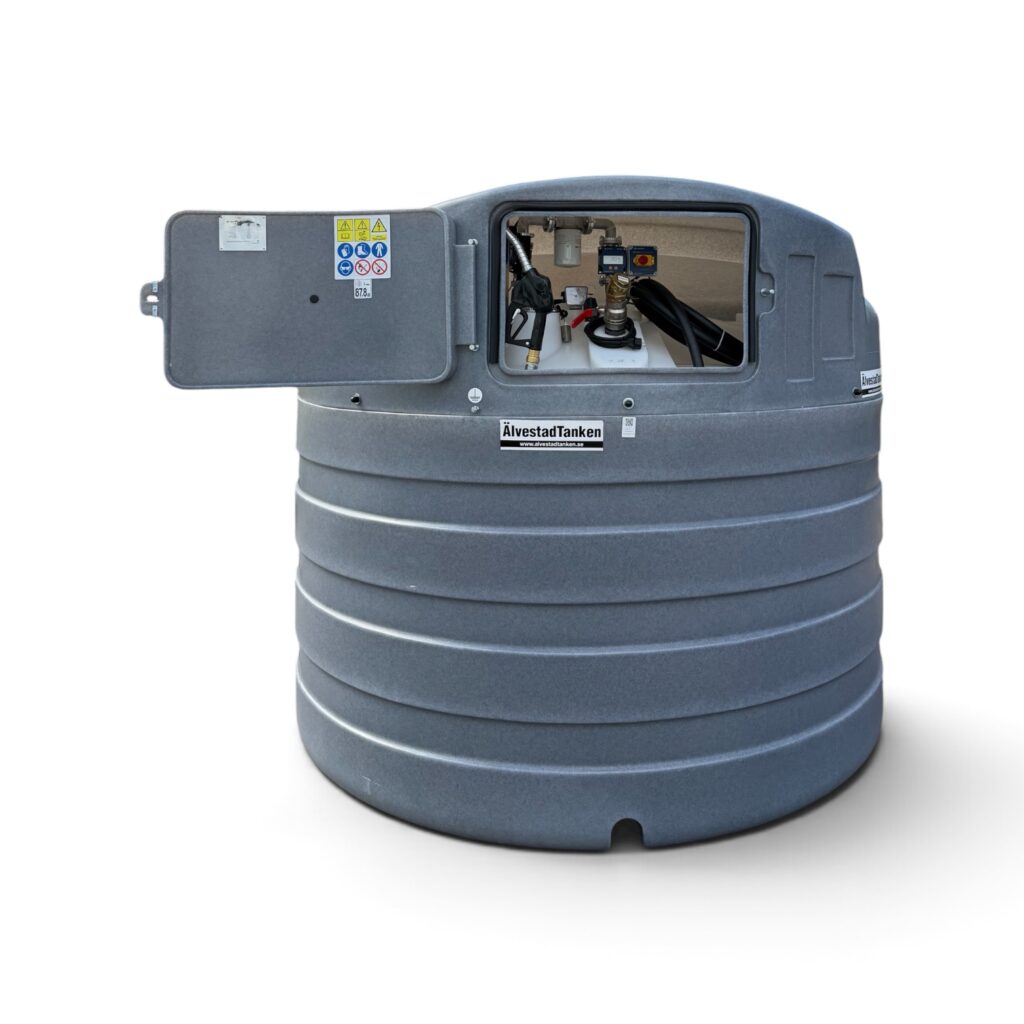 En stor grå cylindrisk tank med texten ”Dieseltank Eco line basic 5000 liter”, med en öppen lucka som visar rör och ventiler inuti. Luckan är försedd med varningsetiketter och symboler.