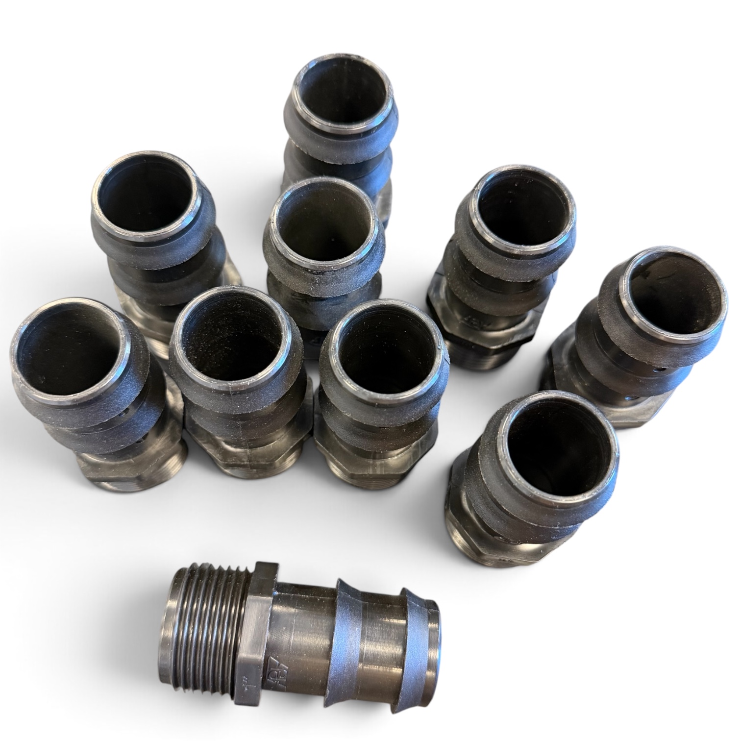 Tio Slangsockel 20 mm x 3/4” med utvändig gänga är placerade upprätt i en grupp, med en ytterligare koppling som ligger horisontellt framför dem, alla mot en vit bakgrund.