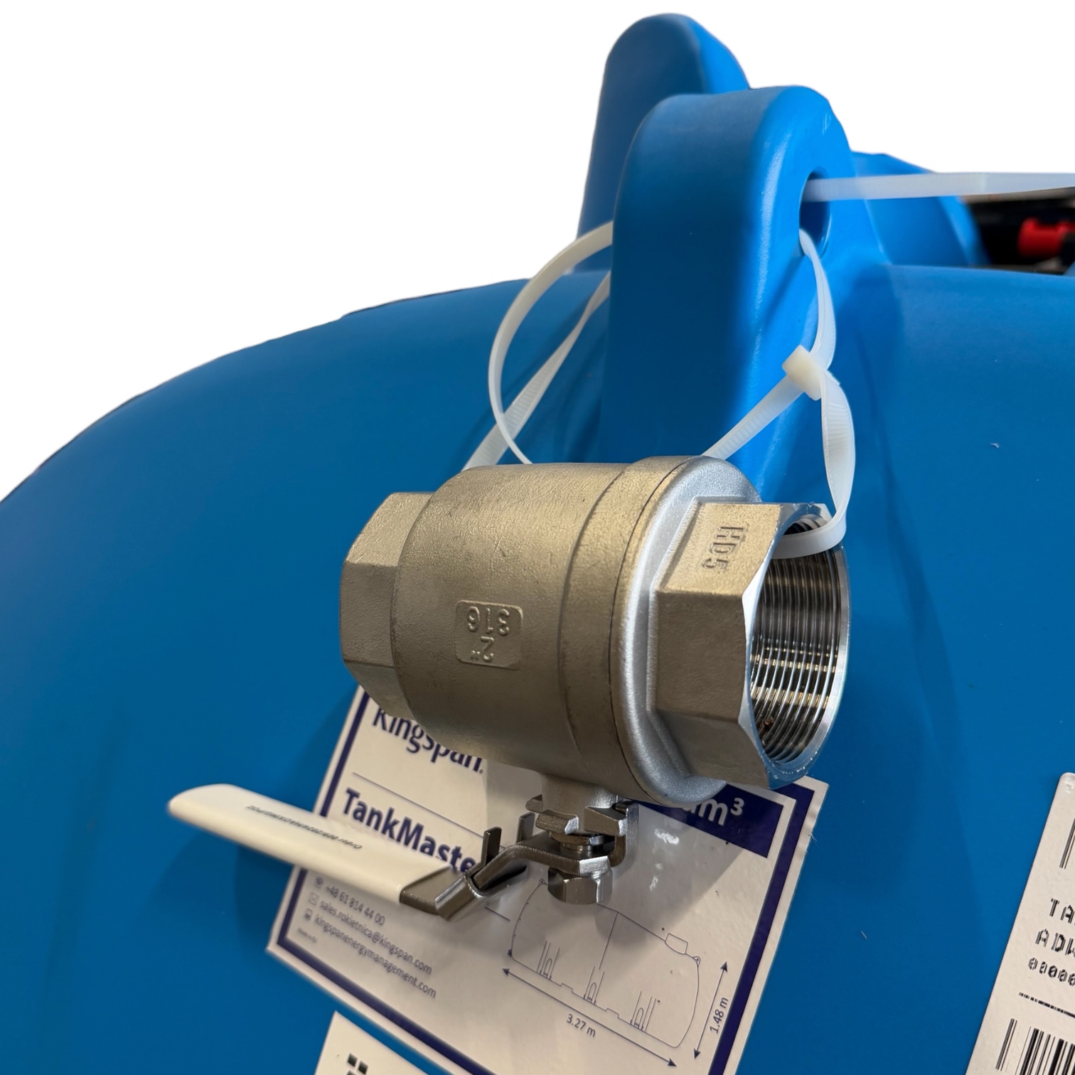 En kulventil i rostfritt stål som är fastsatt med buntband på den blå plastytan på en Aquabank TankMaster-lagringstank på 6 000 liter, godkänd för livsmedel.