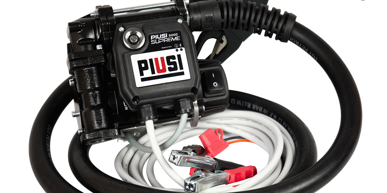 En svart PIUSI 3000 Supreme fjärrstyrd dieselpump (12/24 V) med slang, munstycke och strömkablar med röda och svarta klämmor som är lindade runt den. Har synlig PIUSI-logotyp och metalldelar.